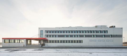 Airline-Catering-, Großküchen- und Logistikzentrum der SCK BBI Immobilien GmbH & Co. KG in Berlin-Schönefeld mit Verwaltung, Produktion, Kühl- und Tiefkühllager sowie Zolllogistik direkt am Flughafen. Industriearchitektur mit optimierten Prozessen, kurzen Wegen und wirtschaftlicher Fertigteilbauweise. Bauherr: SCK BBI Immobilien GmbH & Co. KG. Ort: Berlin-Schönefeld. Geplant und umgesetzt von arc+ GmbH Freudenstadt.